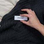 A warm, cozy flat lay featuring candles, a knitted blanket, and a 'Friday' tag, perfect for leisure or relaxation themes.